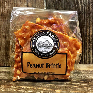 Golden peanut brittle pieces in a 14 oz Bravo Farms bag